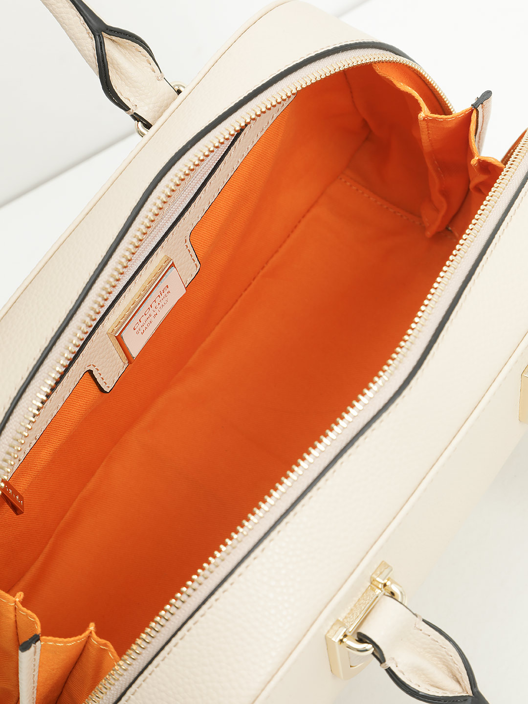 Небольшая сумка трапециевидной формы с жесткими ручками от Cromia из натуральной бежевой кожи