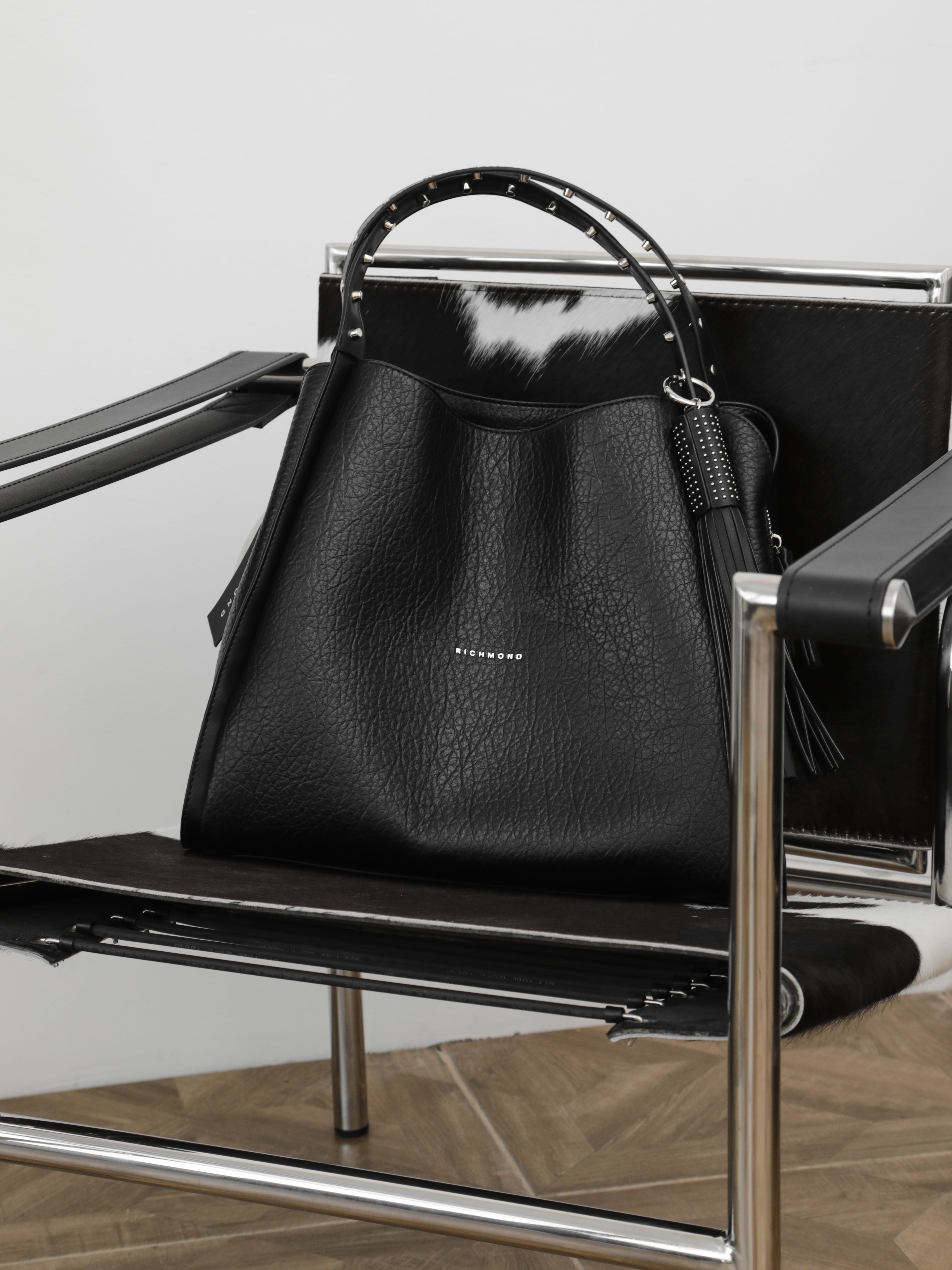 Чёрная сумка с шипами на ручке и пуллером-кисточкой от John Richmond