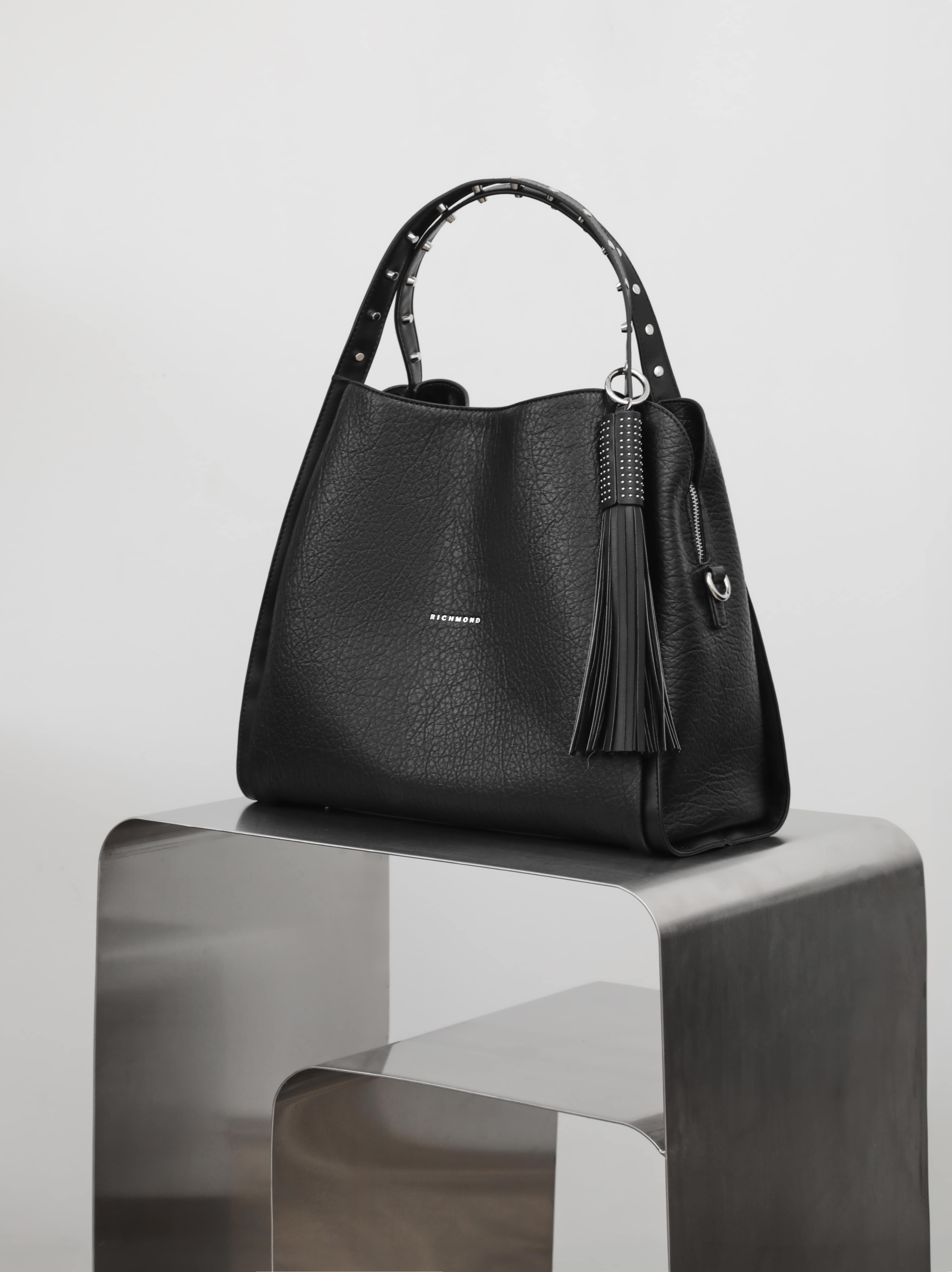 Чёрная сумка с шипами на ручке и пуллером-кисточкой от John Richmond