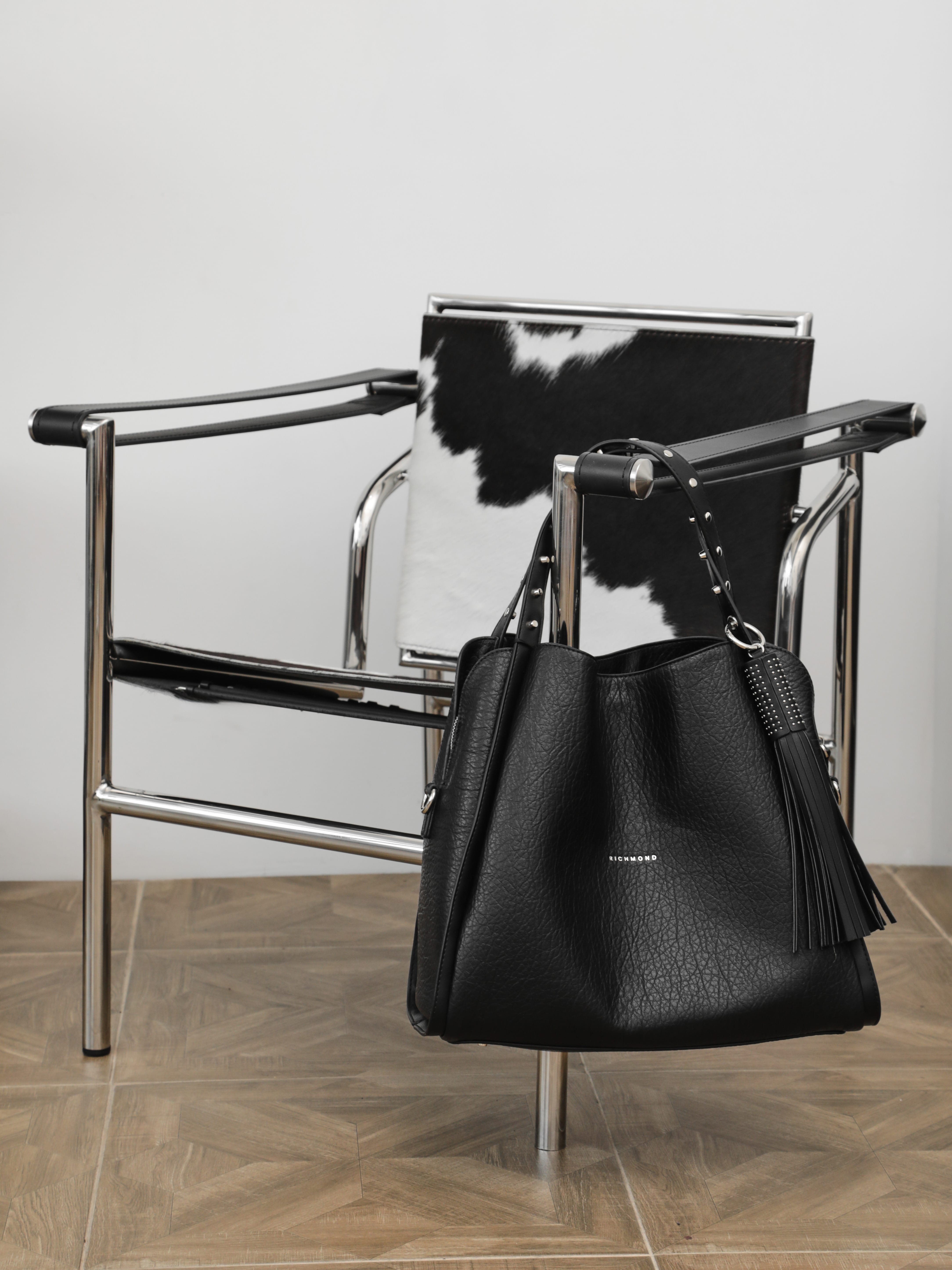 Чёрная сумка с шипами на ручке и пуллером-кисточкой от John Richmond
